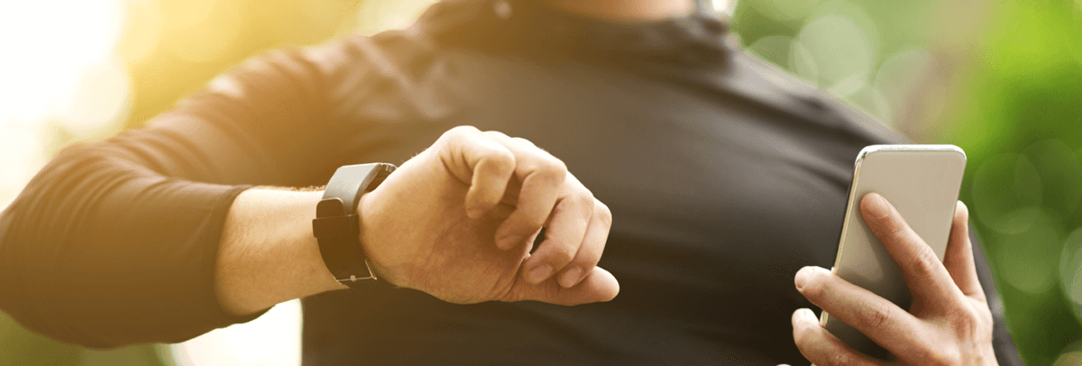 man checking watch and phone